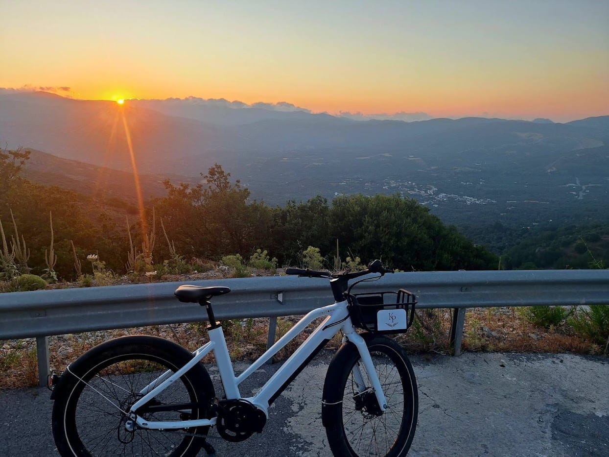 Bicycle in the side of the road with mountain view behind it at sunset