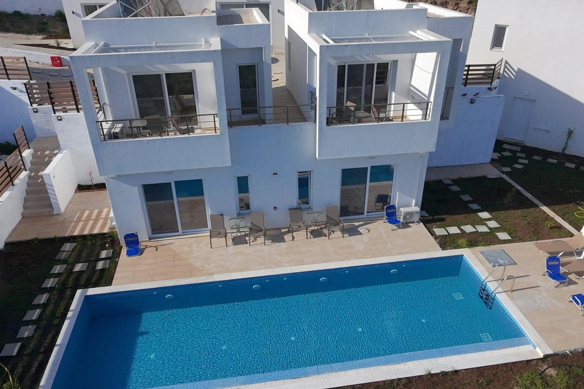 Aerial shot of the building with the pool, garden and stairs