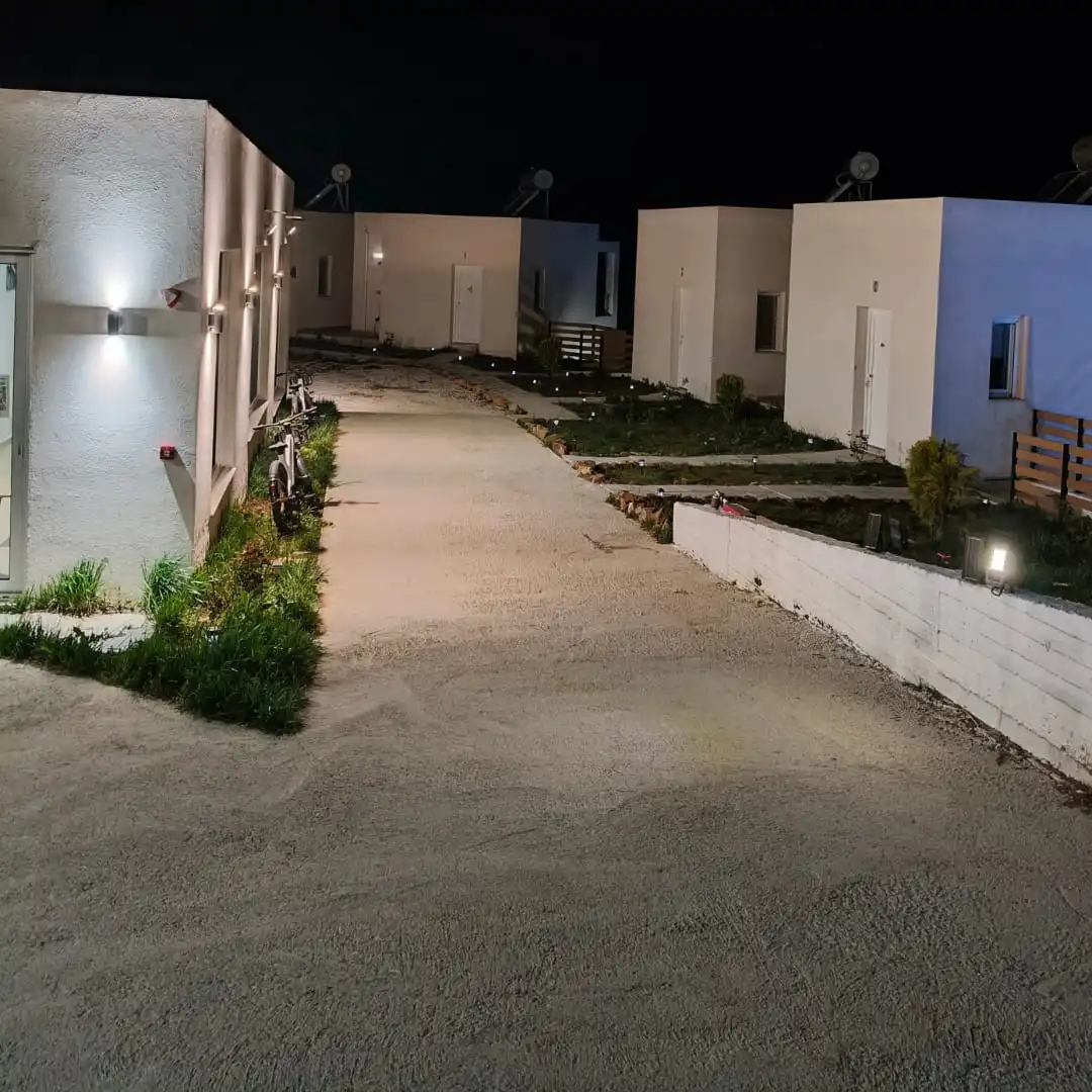 Εξωτερικός χώρος υποδοχής με τα κτίρια των δωματίων τη νύχτα