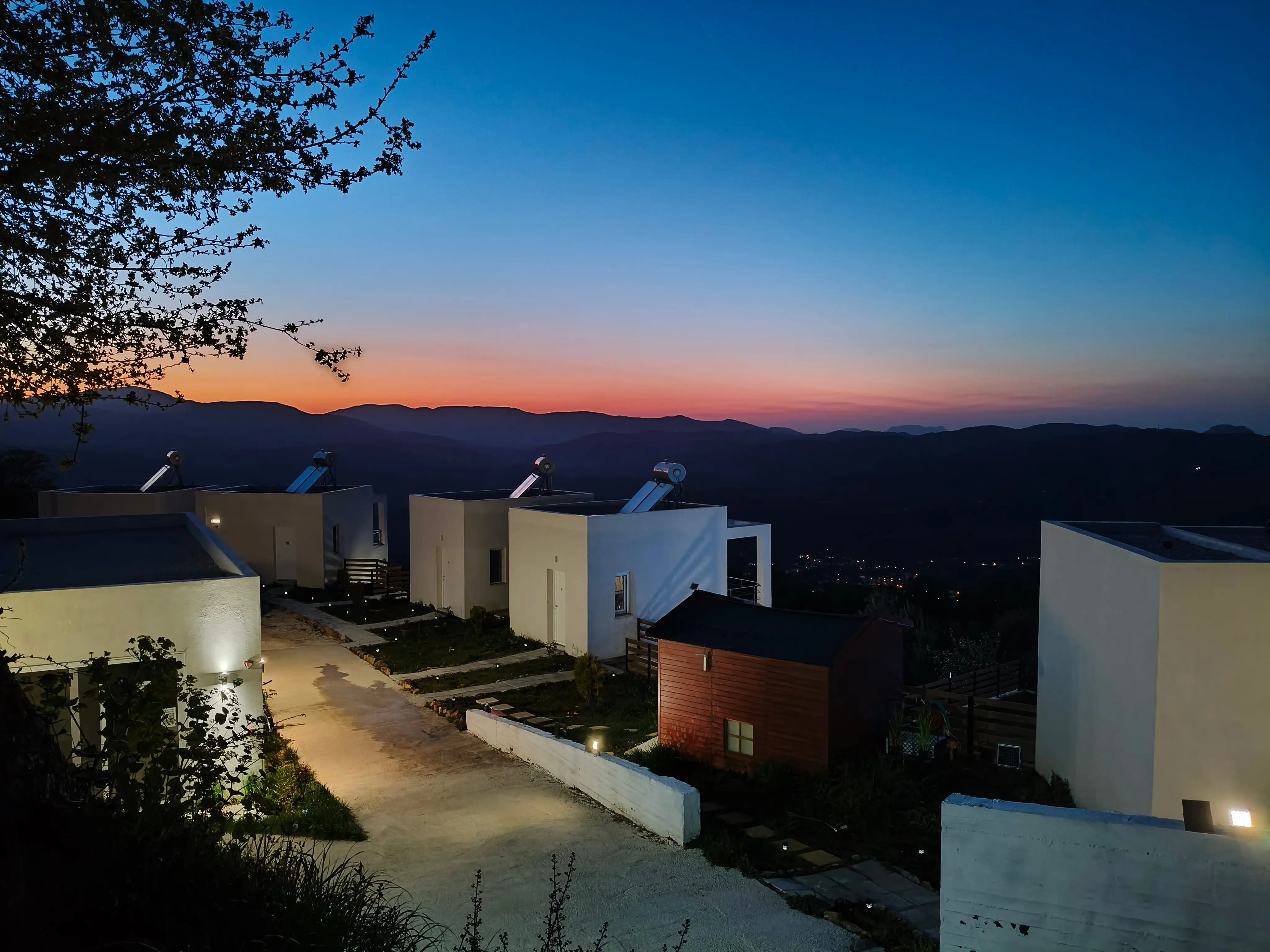 Κτήριο υποδοχής με τα κτίρια των δωματίων και θέα στο βουνό