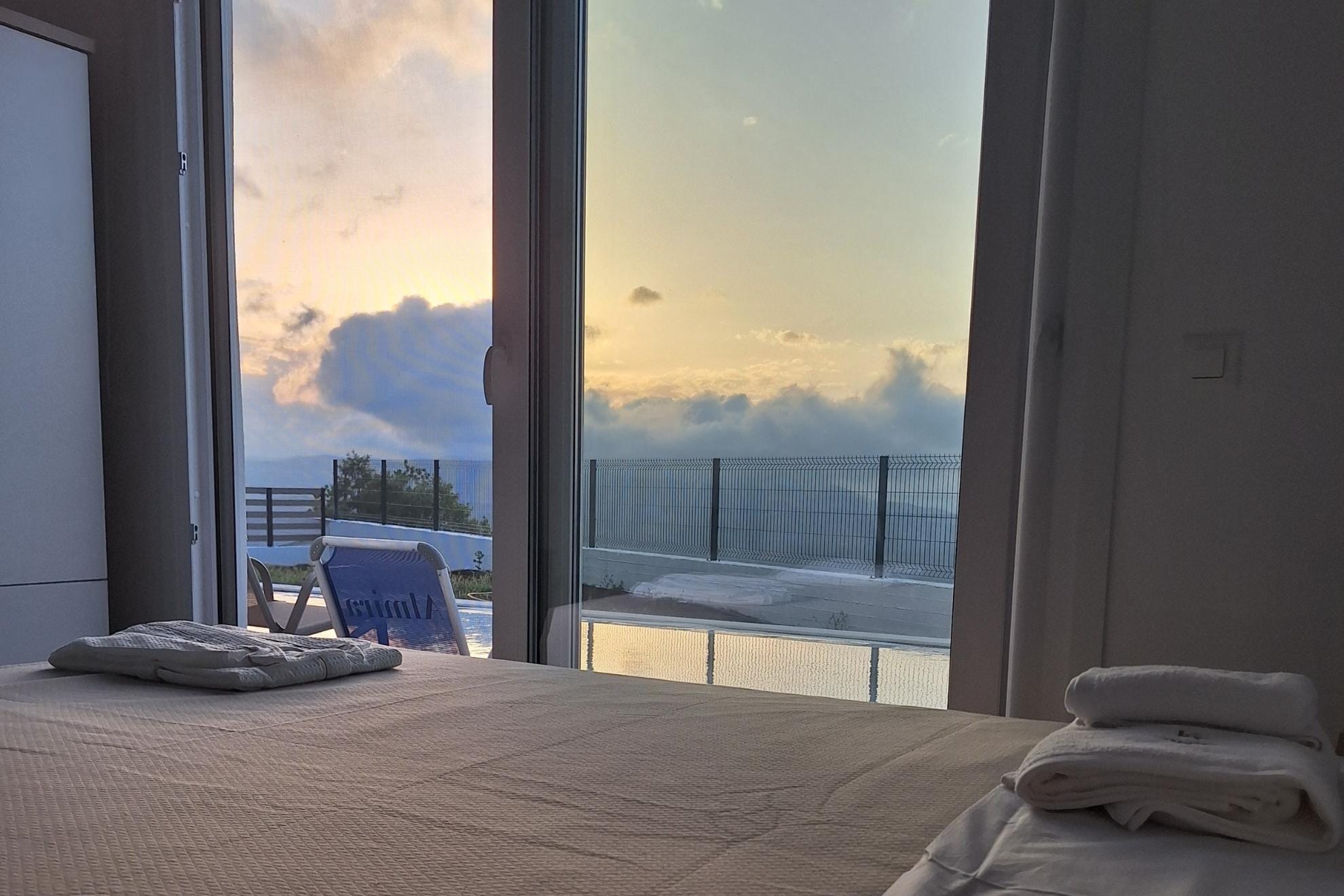 Room with bed, balcony and pool view