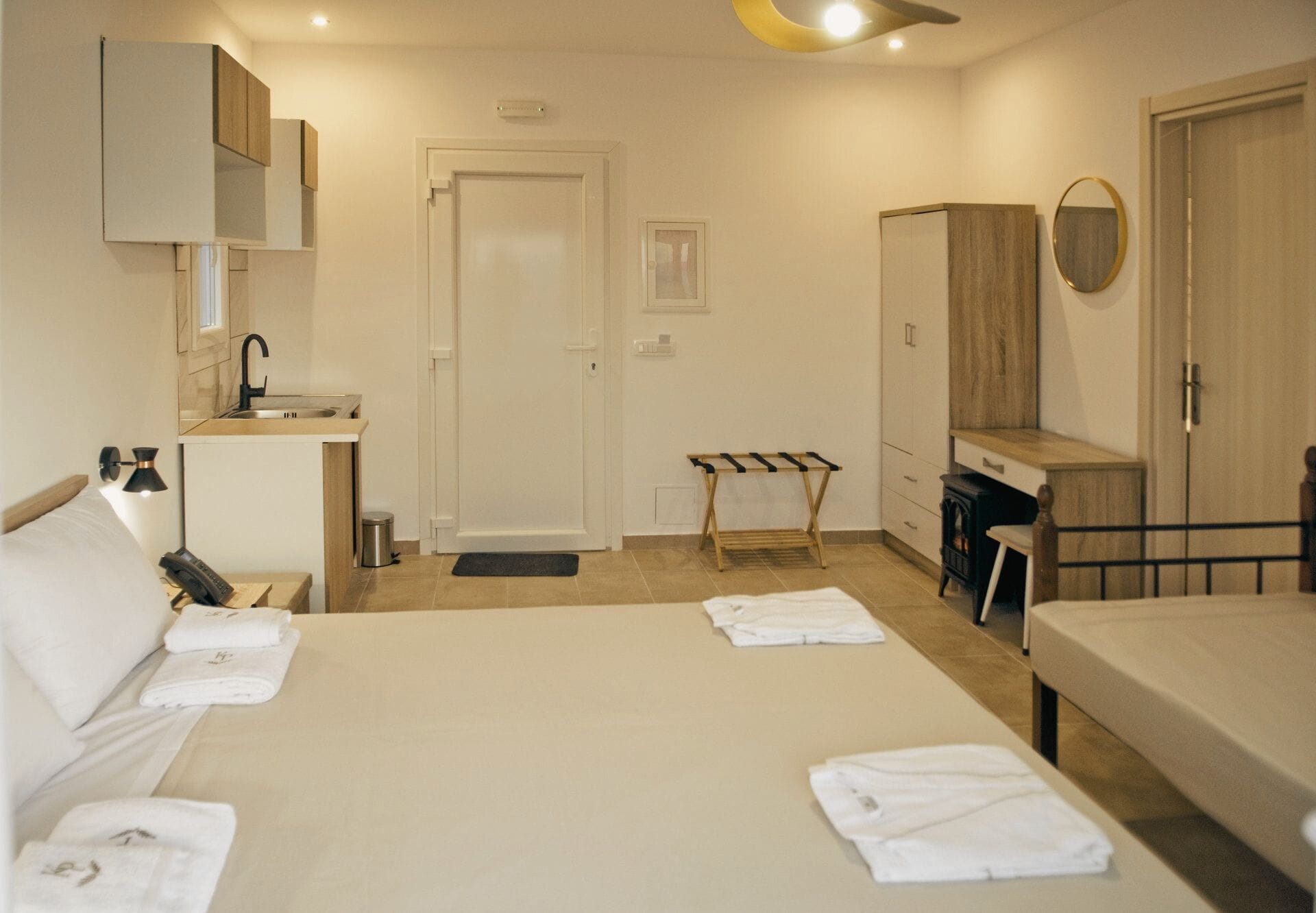 Photo of the room with bed, kitchenette, office and drawer