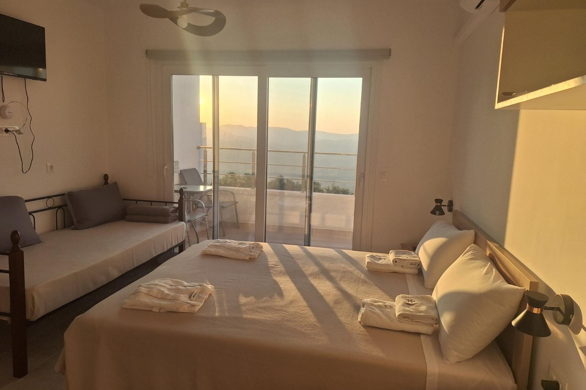 Room with bed, sofa bed, balcony and mountain view